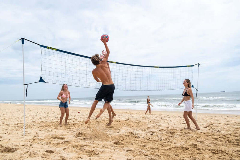 Laden Sie das Bild in Galerie -Viewer, Familie spielt Volleyball am Strand
