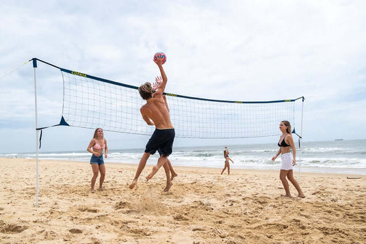 Familie spielt Volleyball am Strand